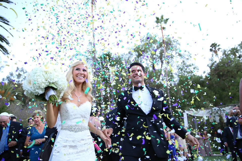 A couple who have just been married and the guests are throwing confetti over them as good luck - Tim Downer Celebrant
